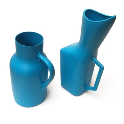 A la izquierda, orinal de plástico masculino Damaco color azul y a la derecha, orinal de plástico femenino Damaco color azul , aislados sobre fondo blanco